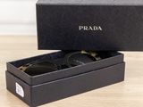 prada sunglasses in a black box on a wooden table