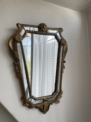 un miroir accroché au mur à côté d'une fenêtre