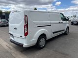 the back of a white van is parked in a parking lot