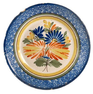 a blue and yellow plate with a flower design on it