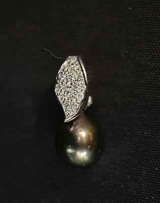 gros plan d'une bague en perles et diamants sur une surface noire