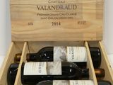 bottles of wine are in a wooden box on a table
