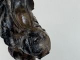 a statue of a horse head on a white wall