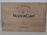 une image représentant une boîte en bois contenant une bouteille de Mouton Cadet