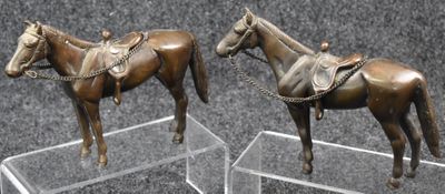 two statues of a horse and a horse with a saddle