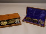 une paire de lunettes plaquées or dans un coffret en bois, posée sur une surface blanche