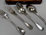 four spoons and a fork sitting next to each other