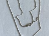 un gros plan sur un collier en argent orné d'un triangle