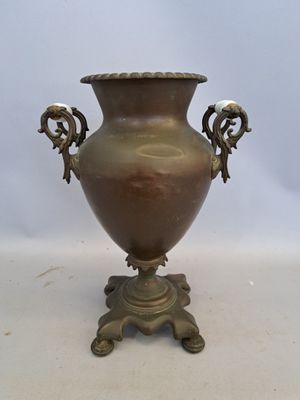 un vase en bronze à deux anses, posé sur un socle