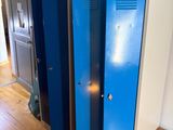 un casier bleu dans un coin de la pièce, à côté d'un bureau