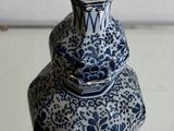 a blue and white vase sitting on top of a stack of books