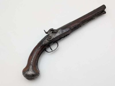 an old gun on a white surface with a white background
