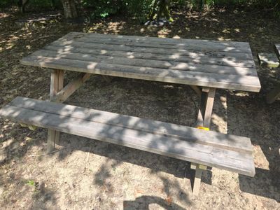 a wooden picnic table in the middle of the woods