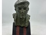 statue d'un homme coiffé d'un béret, posée sur un socle noir