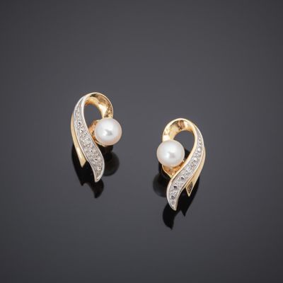 a pair of pearl and diamond earrings on a black surface
