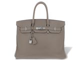 a grey leather bag with a lock on the handle