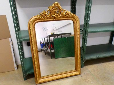 un miroir posé par terre à côté d'une étagère