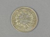 a close up of a coin on a table with a white background