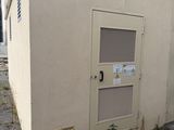 un petit bâtiment dont la porte se trouve sur le côté