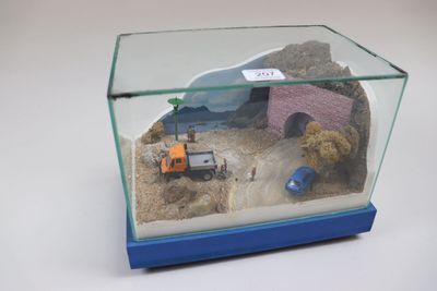une petite maquette représentant un chantier, exposée dans une vitrine