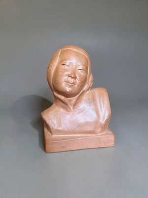 a small statue of a woman sitting on a table
