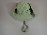 a green hat hanging on a hook on the wall