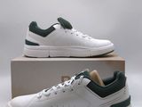 a pair of white and green sneakers sitting on top of a box
