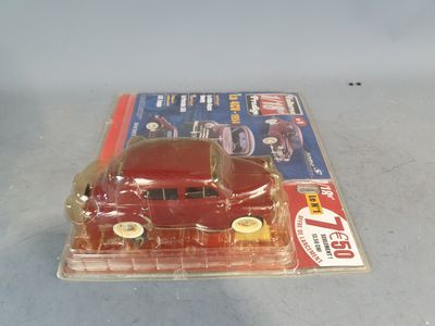 a red toy car sitting on top of a magazine