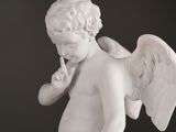 statue of a little angel with a finger on his lips