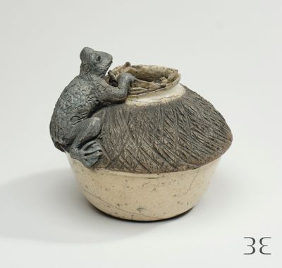 un petit vase sur lequel est perchée une souris