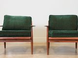 two green chairs sitting next to each other on a hard wood floor