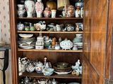 a cabinet that has many different types of china on it