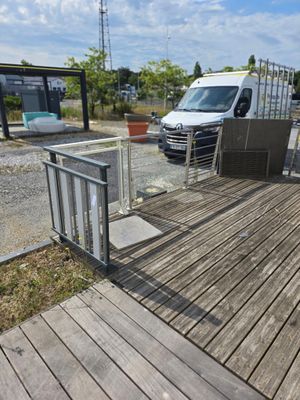 une camionnette blanche garée sur un parking près d'une clôture