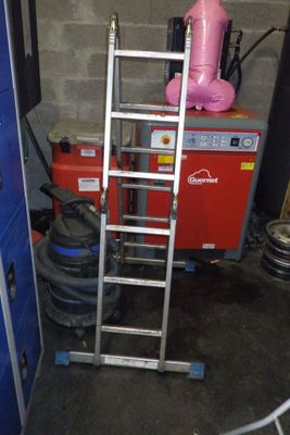 une échelle qui se trouve à côté d'une porte bleue