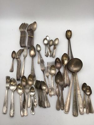 a lot of silver spoons and spoons on the table