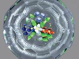 un bol en verre contenant des fleurs, posé sur une table