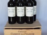 six bouteilles de vin rouge dans une caisse en bois sur une table
