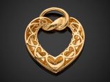 a close up of a gold heart pendant on a black background