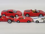 several toy cars are lined up in a row on a white surface