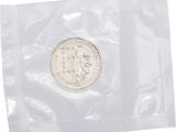 un gros plan d'une pièce de monnaie dans un sachet en plastique sur fond blanc