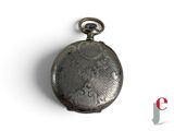 a silver pocket watch that is on display on a white surface