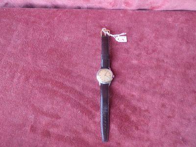 a watch that is laying on a red cloth