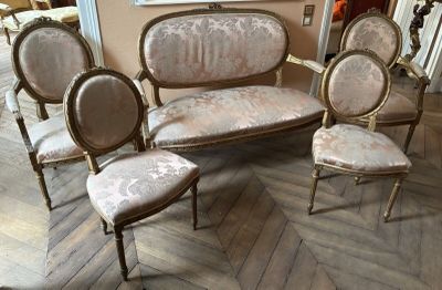 several chairs and a couch in a room with a painting on the wall