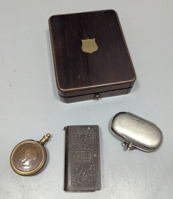 une petite boîte en métal avec une pochette et un porte-clés à côté