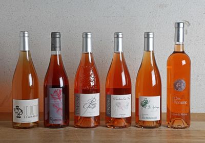 plusieurs bouteilles de vin sont alignées sur une table en bois
