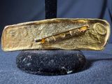 gold plated knife on a black rock with a knife in the middle