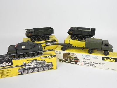 Trois véhicules militaires miniatures sont exposés sur une surface blanche