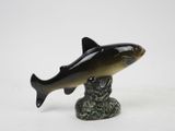 figurine of a fish on a pedestal on a white background