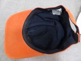 an orange and black hat sitting on top of a couch