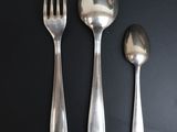 three spoons and a fork on a black table